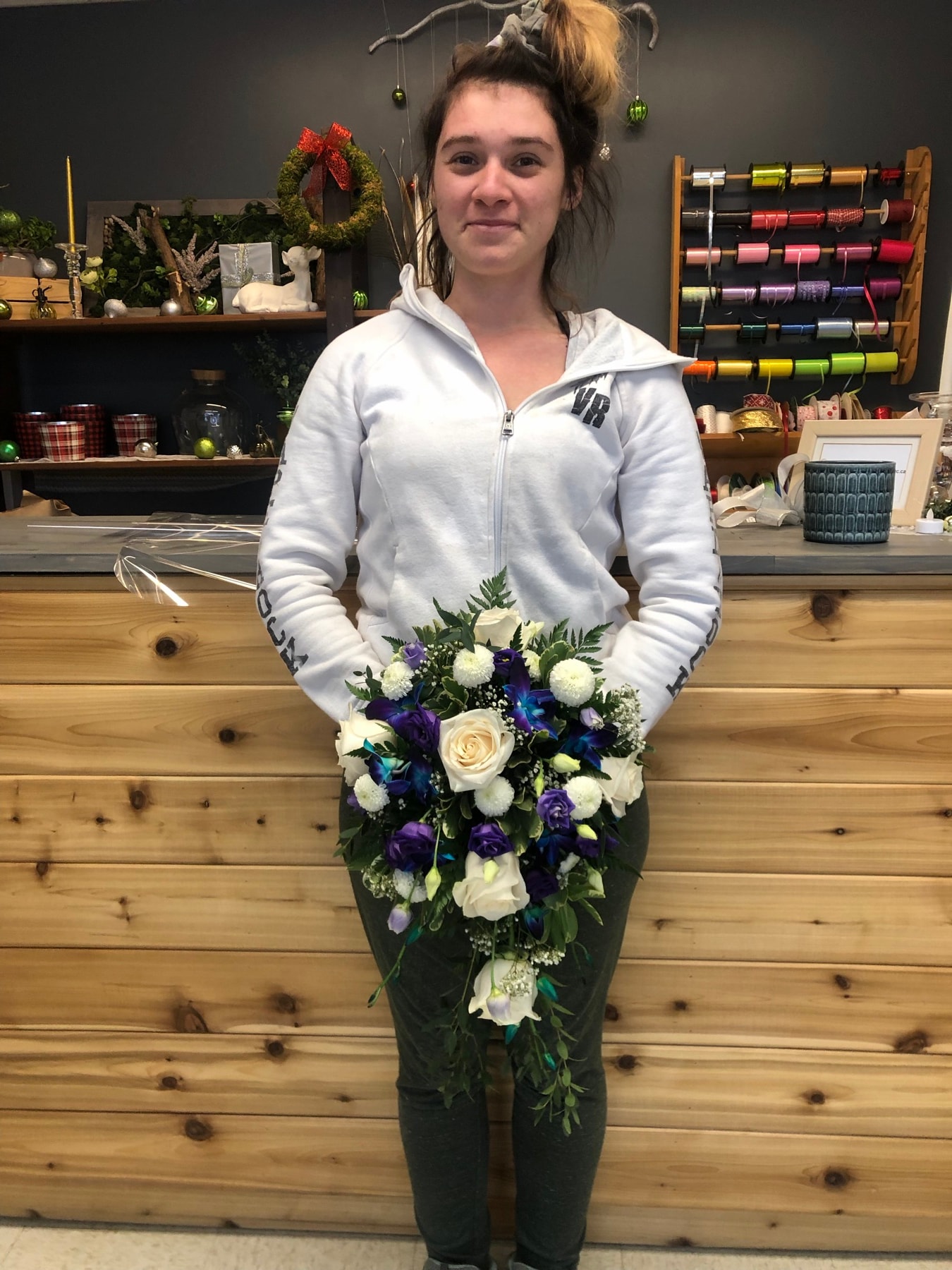 Molly tenant un bouquet de fleurs, dans l'atelier de fleuristerie